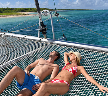 Couple enjoying sunbathing on a yacht - Caribbean Charter
